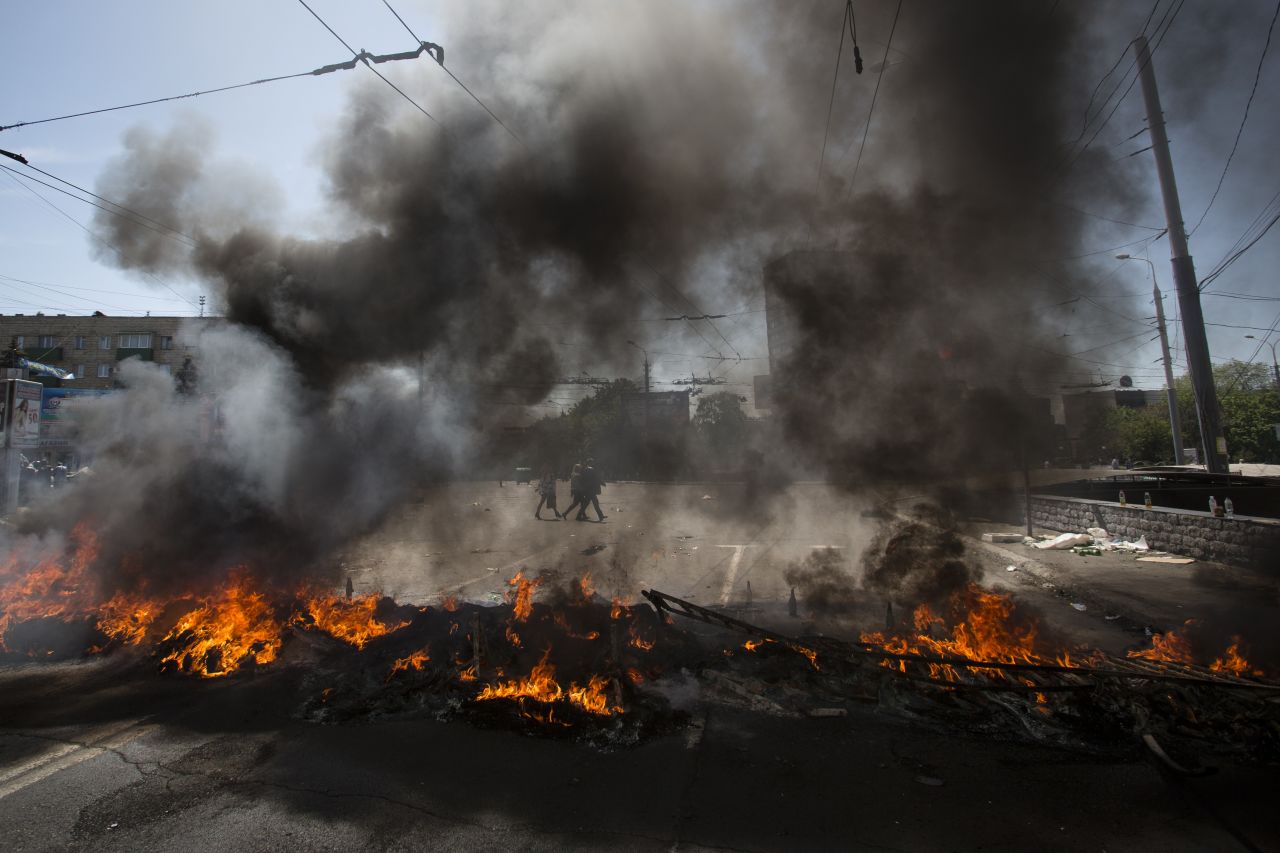 Black smoke billows from burning tires used to prevent government troops' armored personnel carriers from passing through in Mariupol on Saturday, May 10. 