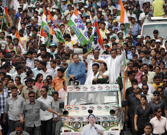 Trinamool Congress Chairwoman Mamata Banerjee, with microphone, campaigns for Jadavpur TMC candidate Sugata Bose, left, and South Kolkata candidate Subrata Bakshi, center, with Mithun Chakraborty on May 10 in Kolkata.