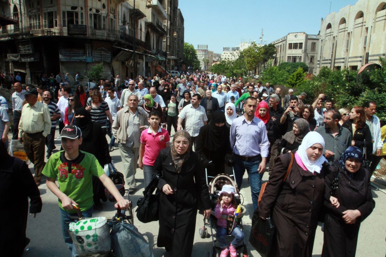 Residents carry their belongings in the al-Hamidieh neighborhood of Homs on May 10.