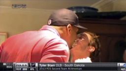 In this image taken from video, Missouri defensive end Michael Sam, left, gets a kiss at a draft party in San Diego, before he was selected in the seventh round, 249th overall, by the St. Louis Rams in the NFL draft.