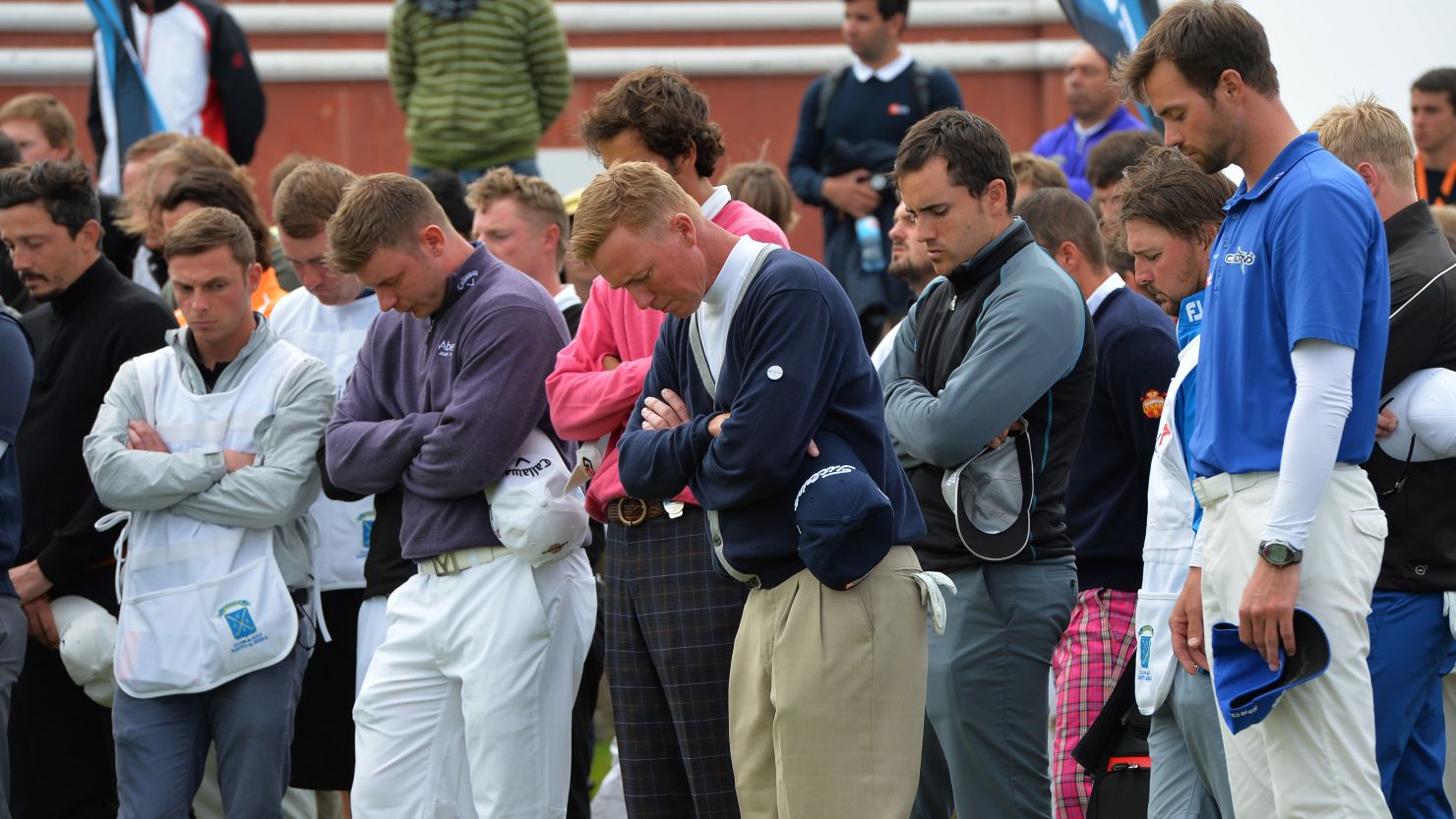 Players and caddies observe a minute's silence for Iain McGregor following his death at the Madeira Islands Open.
