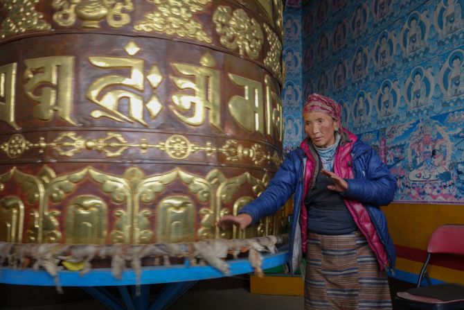 Ang Riku spins a prayer wheel at Laudo monastery, repeating the mantra "Om Mani Padme Hum" to accumulate merit for her husband.