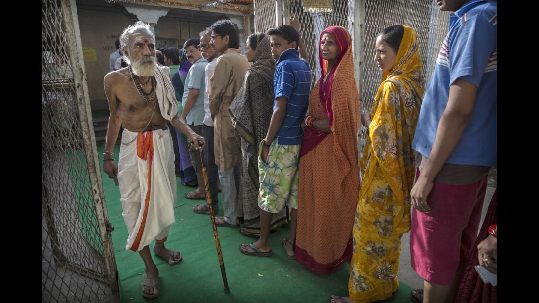 A Hindu holy man passes a line of people after voting at a polling station Monday, May 12, in Varanasi during the ninth and final phase of elections. 
