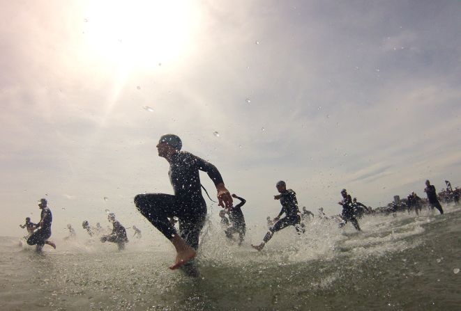 Participants run into the sea to begin the swimming leg of the Challenge Rimini triathlon on Sunday, May 11, in Rimini, Italy.