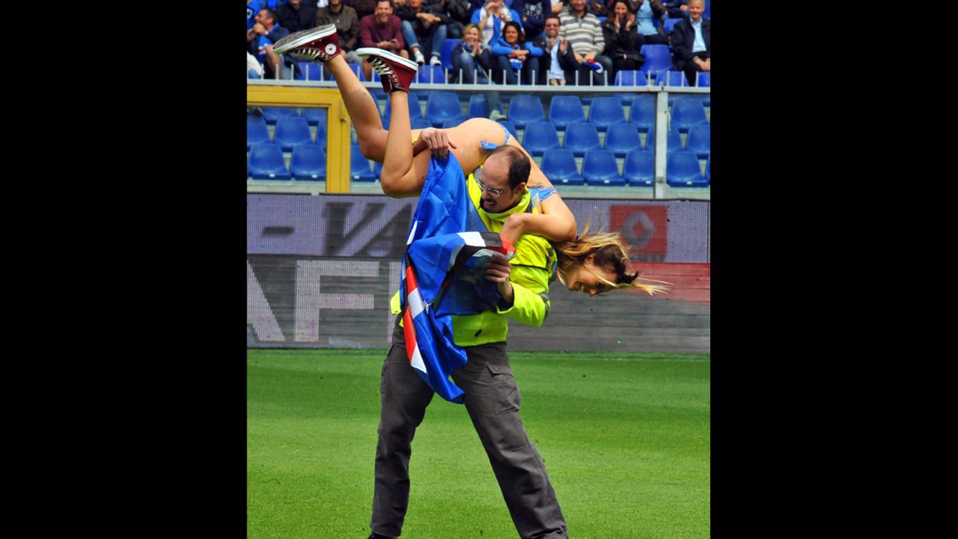 A steward carries a streaker from the pitch during the Italian Series A soccer match between UC Sampdoria and SSC Napoli at Luigi Ferraris stadium in Genova, Italy, on Sunday, May 11.