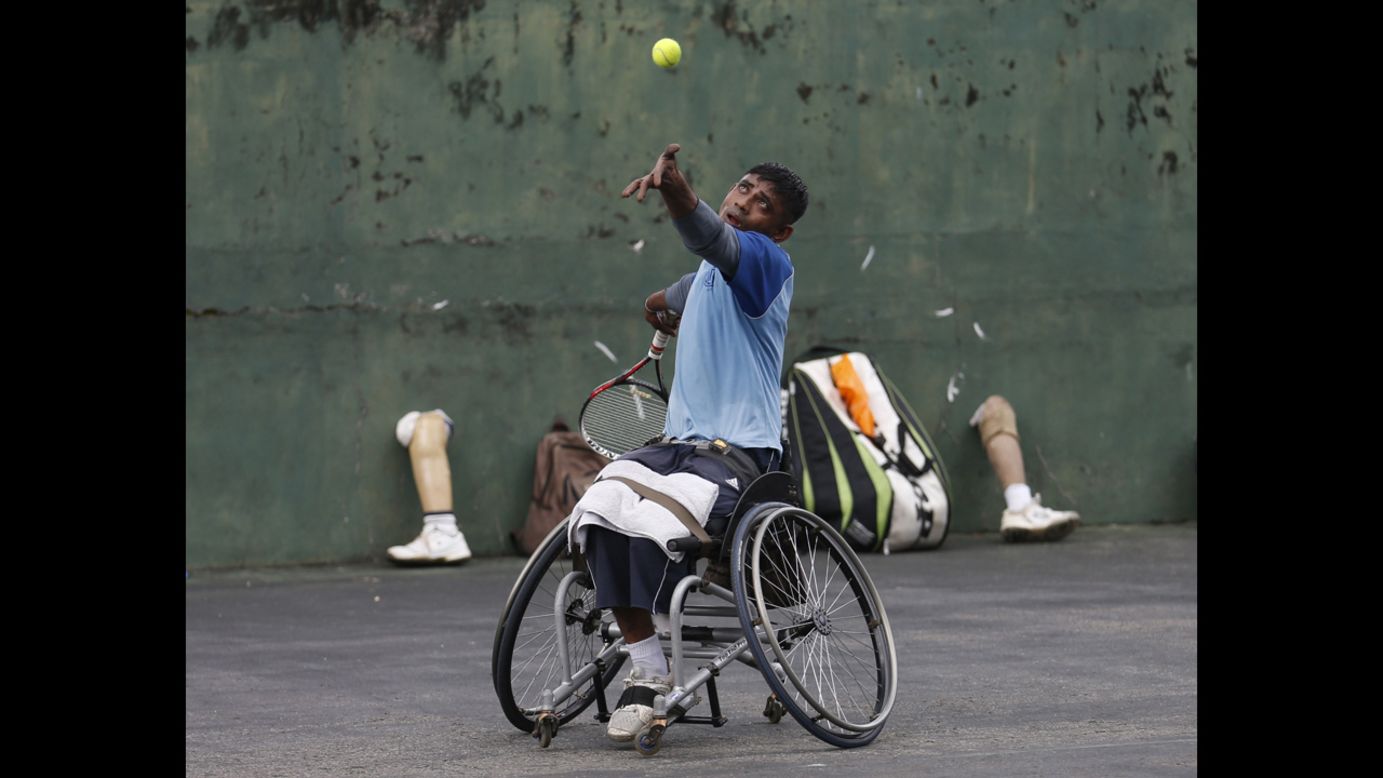 Gamini Dissanayake, a member of Sri Lanka's wheelchair tennis national team, serves during a practice session in Colombo on Tuesday, May 6. The team is made up of soldiers who lost their limbs during active duty.