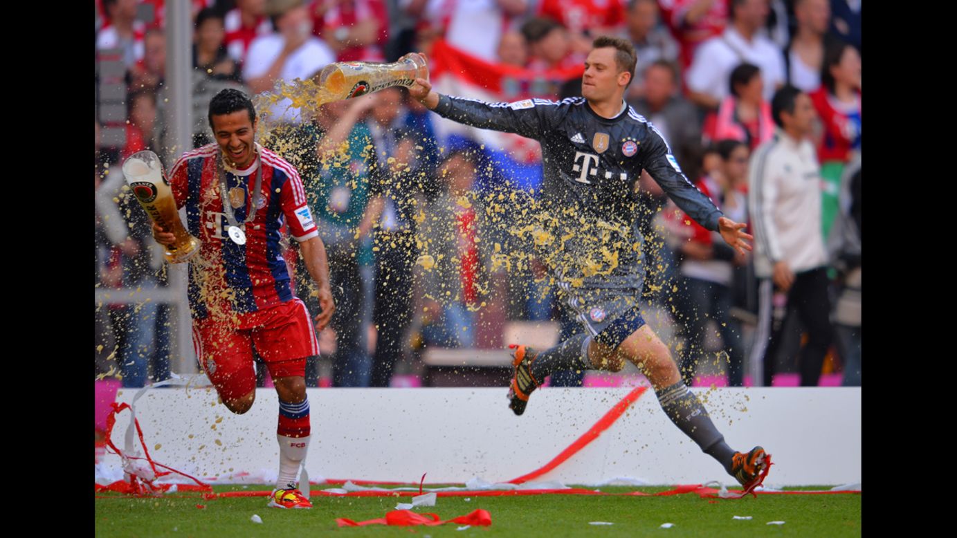Manuel Neuer of Bayern Muenchen pours beer on teammate Thiago Alcantara as they celebrate after the Bundesliga match against VfB Stuttgart at Allianz Arena in Munich, Germany, on Saturday, May 10.