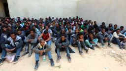 Some of the 340 illegal migrants who were rescued by the Libyan navy off the coast of the western town of Sabratha when their boat began to take on water, sit at a shelter on May 12, 2014 in the coastal town of Zawiya, west of Tripoli. The rescue came on the same day Italy's navy said at least 14 migrants had died when their boat sank between Libya and Italy, the latest in a string of shipwreck tragedies to hit the Mediterranean. Libya has long been a springboard for Africans seeking a better life in Europe, and the number of illegal departures from its shores is rising. AFP PHOTO / MAHMUD TURKIA        (Photo credit should read MAHMUD TURKIA/AFP/Getty Images)