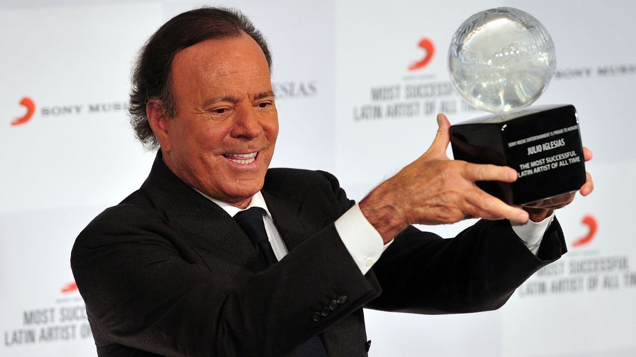 Spanish singer Julio Iglesias holds an award after being named the most successful Latin artist of all time at a press conference in London on May 12, 2014. AFP PHOTO / CARL COURTCARL COURT/AFP/Getty Images