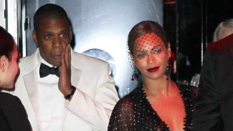 Jay Z touches his face as he leaves the Standard Hotel with his wife, Beyonce. Earlier surveillance footage from a hotel elevator showed what appeared to be Jay Z's sister-in-law first lunging at him, then swinging and kicking him, while a woman resembling Beyonce stood quietly to the side.