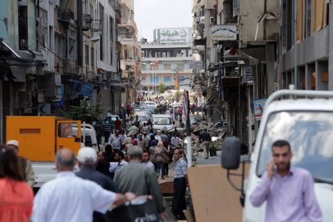 People pack the streets of Homs on May 12, days after the last rebel holdouts left the city.