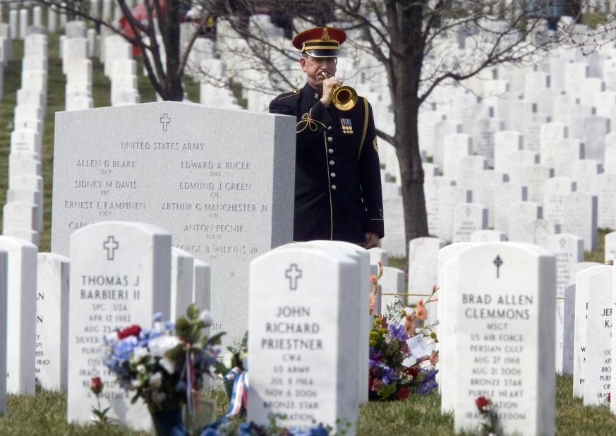 An Arlington National Cemetery Honor Guard bugler plays taps during funeral services for Army Spc. Ross Andrew McGinnis, who was killed in Iraq in December 2006.