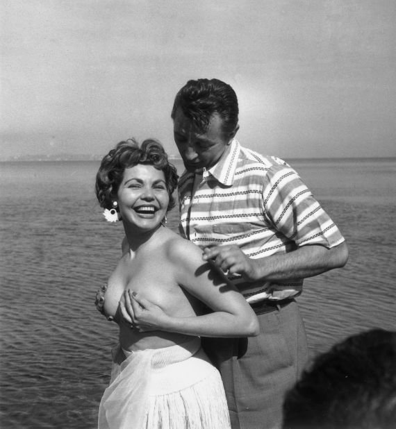 Starlet Simone Silva poses topless with idol Robert Mitchum in 1954.