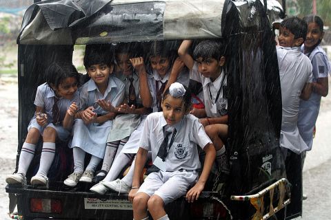 Motorized rickshaws provide affordable transit for the masses, helping people get to work and functioning as a school bus for these school children in Amritsar, India. 
