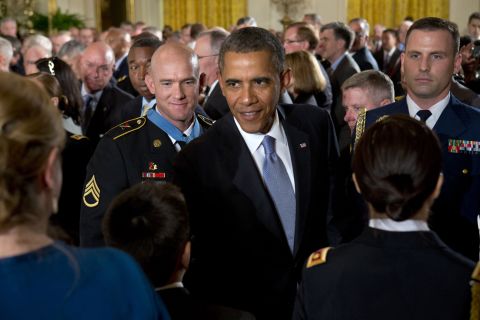 Army Staff Sgt. Ty M. Carter, left, watches as Obama greets family members of fallen service members after Carter was awarded the Medal of Honor in August 2013. Carter was cited for his actions during the October 3, 2009, defense of Command Outpost Keating in Afghanistan, including "running through a hail of enemy rocket propelled grenade and machine gun fire to rescue a critically wounded comrade."
