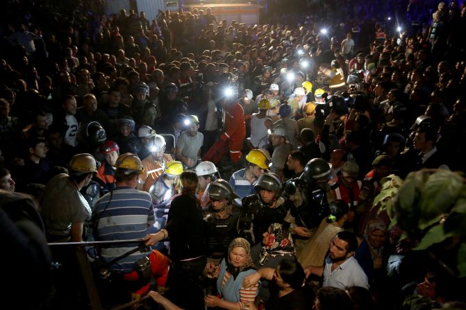 Una gran multitud observa mientras los equipos de rescate trabajan en la noche.