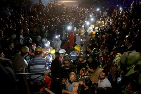 A massive crowd watches as rescuers work into the night.