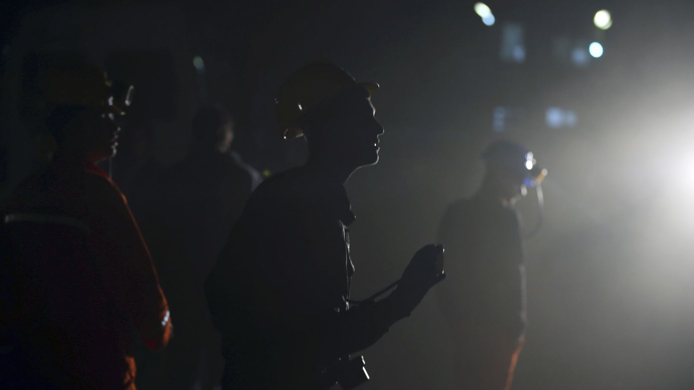 Mineros esperan fuera de la mina en las primeras horas del 14 de mayo.