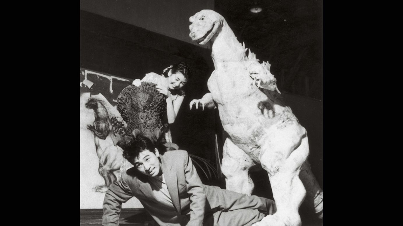 "Godzilla" stars Akira Takarada, bottom, and Momoko Kochi clown around at Toshimitsu's fabrication studio with the unfinished monster costume in 1954. 