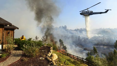 A helicopter drops water near the Rancho Santa Fe neighborhood of San Diego on Tuesday, May 13.