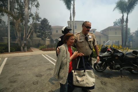 A woman is escorted to safety May 14 in Carlsbad. 