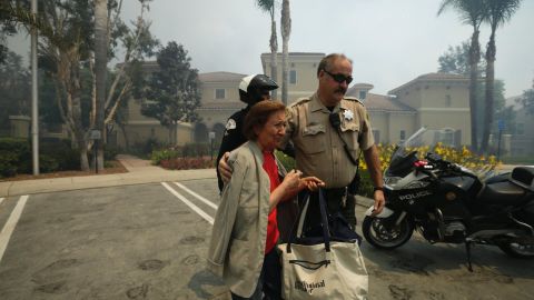 A woman is escorted to safety May 14 in Carlsbad.