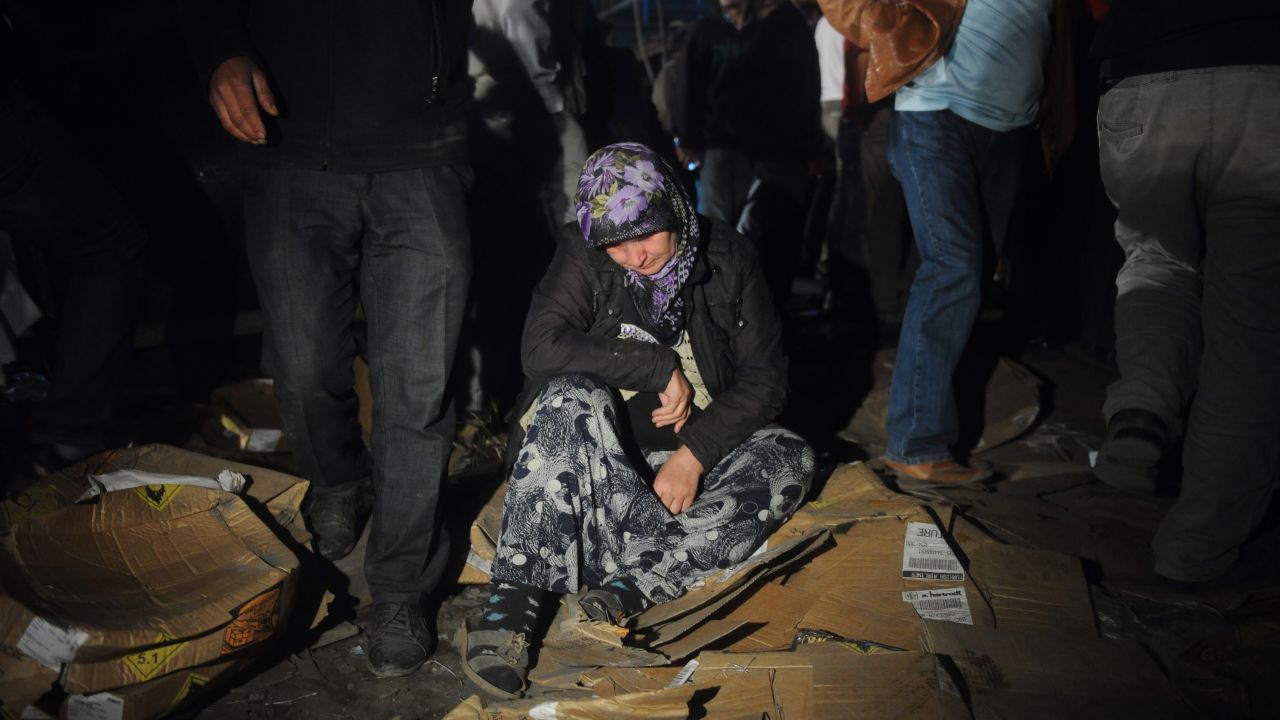 A woman waits on the ground at the disaster scene Wednesday, May 14.