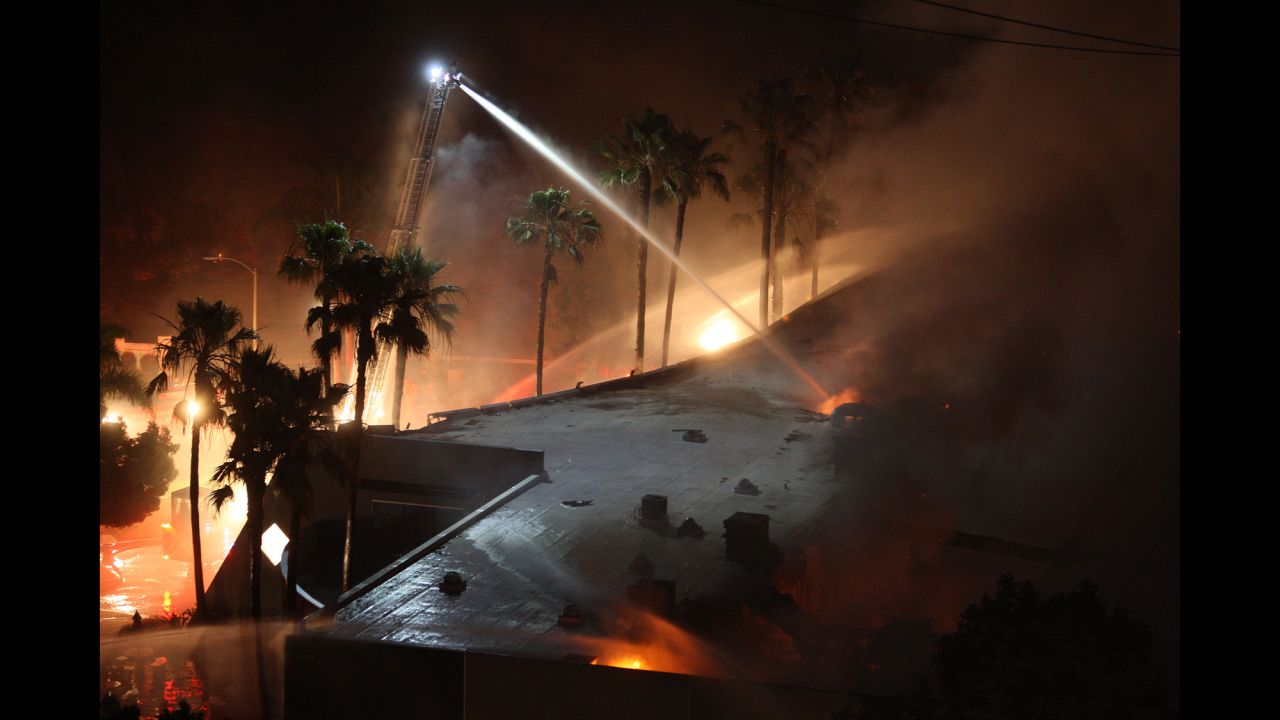 Firefighters spray water on a burning building in Carlsbad, California.