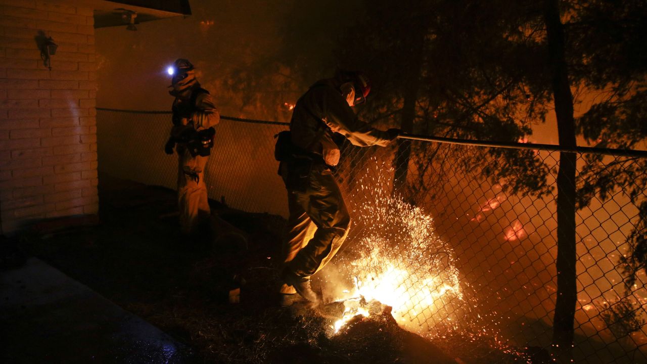 A firefighter puts out a spot fire in San Marcos.
