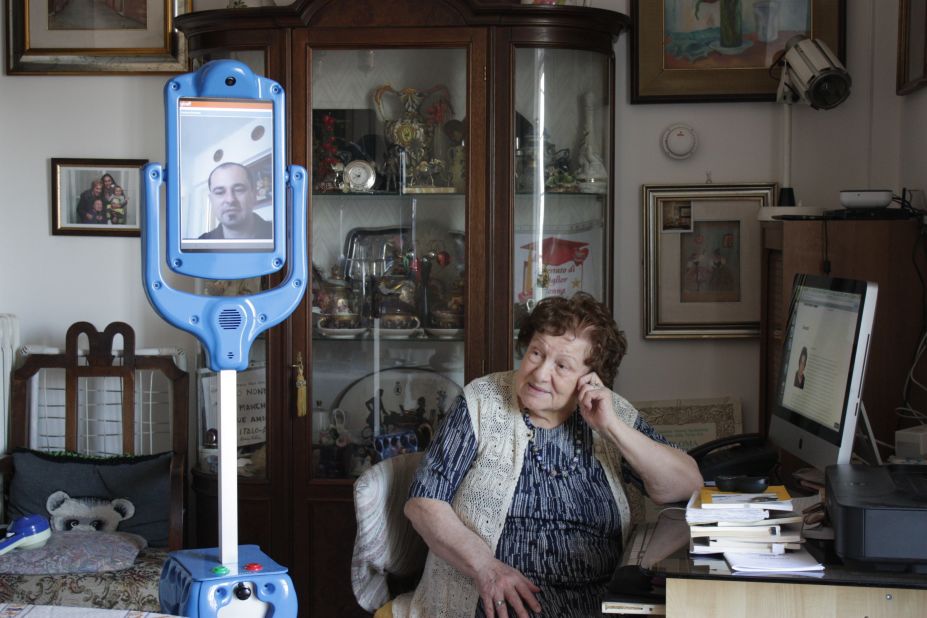 This Italian woman is being assisted by the Giraffplus robot carer at her Rome apartment. The Giraffplus is connected to sensors that measure indicators such as blood pressure and communicate with medical staff.