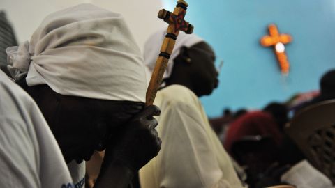 File photo: A Sudanese woman holds a cross as she prays.