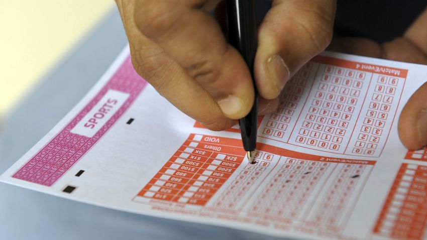 This illustration taken on December 10, 2013 shows a person filling out a sports betting slip. It's one of the world's smallest and wealthiest countries, but a deep gambling culture coupled with sheer entrepreneurial zeal has made Singapore a big player in global match-fixing, experts say. AFP PHOTO/ROSLAN RAHMAN (Photo credit should read ROSLAN RAHMAN/AFP/Getty Images