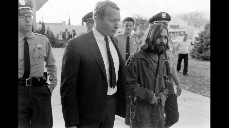 Cult leader Charles Manson is taken into court to face murder charges on December 5, 1969, in Los Angeles. At Manson's command, a small group of his most ardent followers brutally murdered five people at the Los Angeles home of film director Roman Polanski on August 8-9, 1969, including Polanski's pregnant wife, actress Sharon Tate. Manson was convicted for orchestrating the murders and sentenced to death. The sentence was later commuted to life in prison.