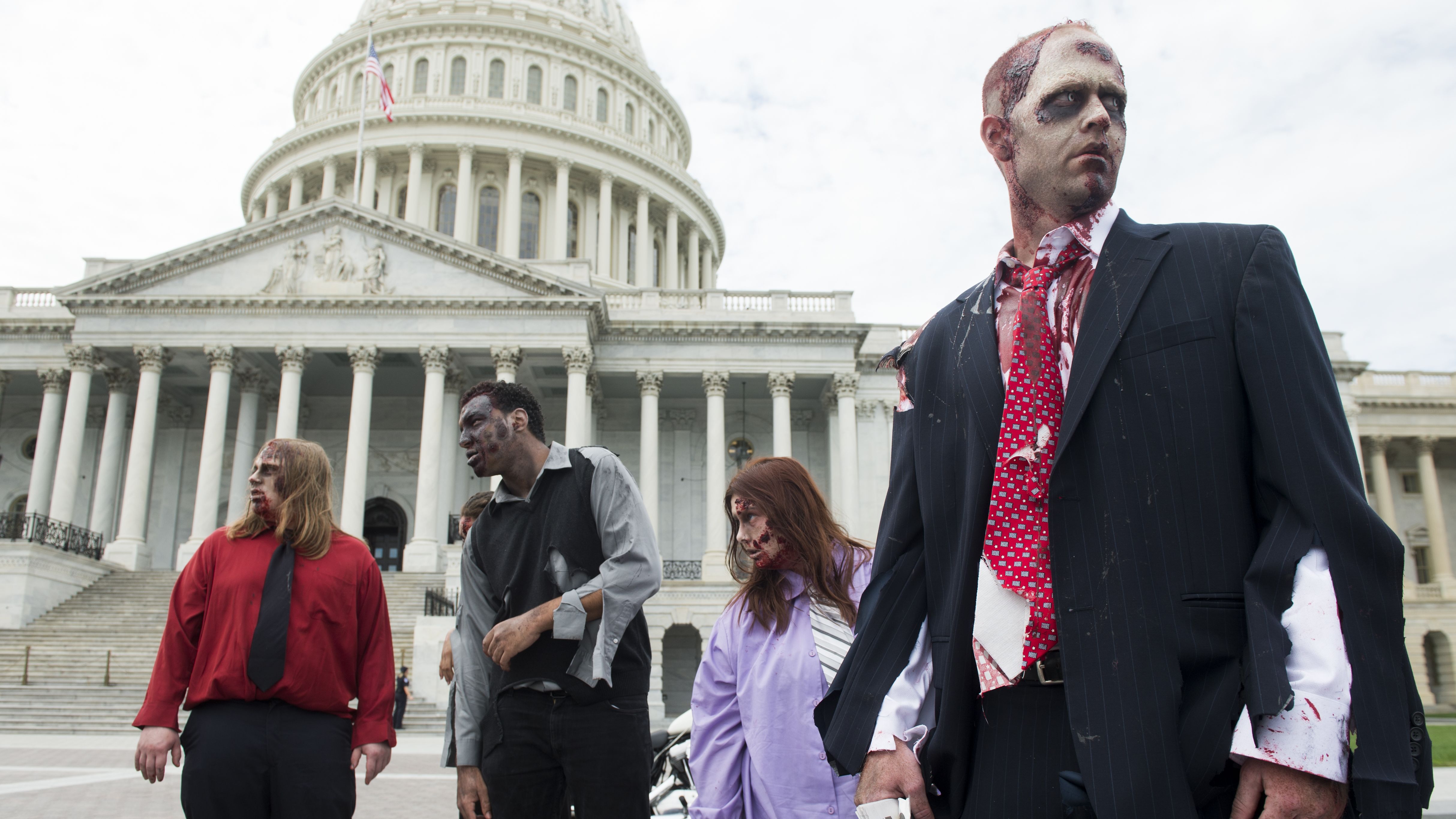  Zombies stumble across the East Plaza of the U.S. Capitol to promote 'The Warehouse: Project 4.1' urban haunted house in Rockville, Maryland, on Wednesday, October 3, 2012. 