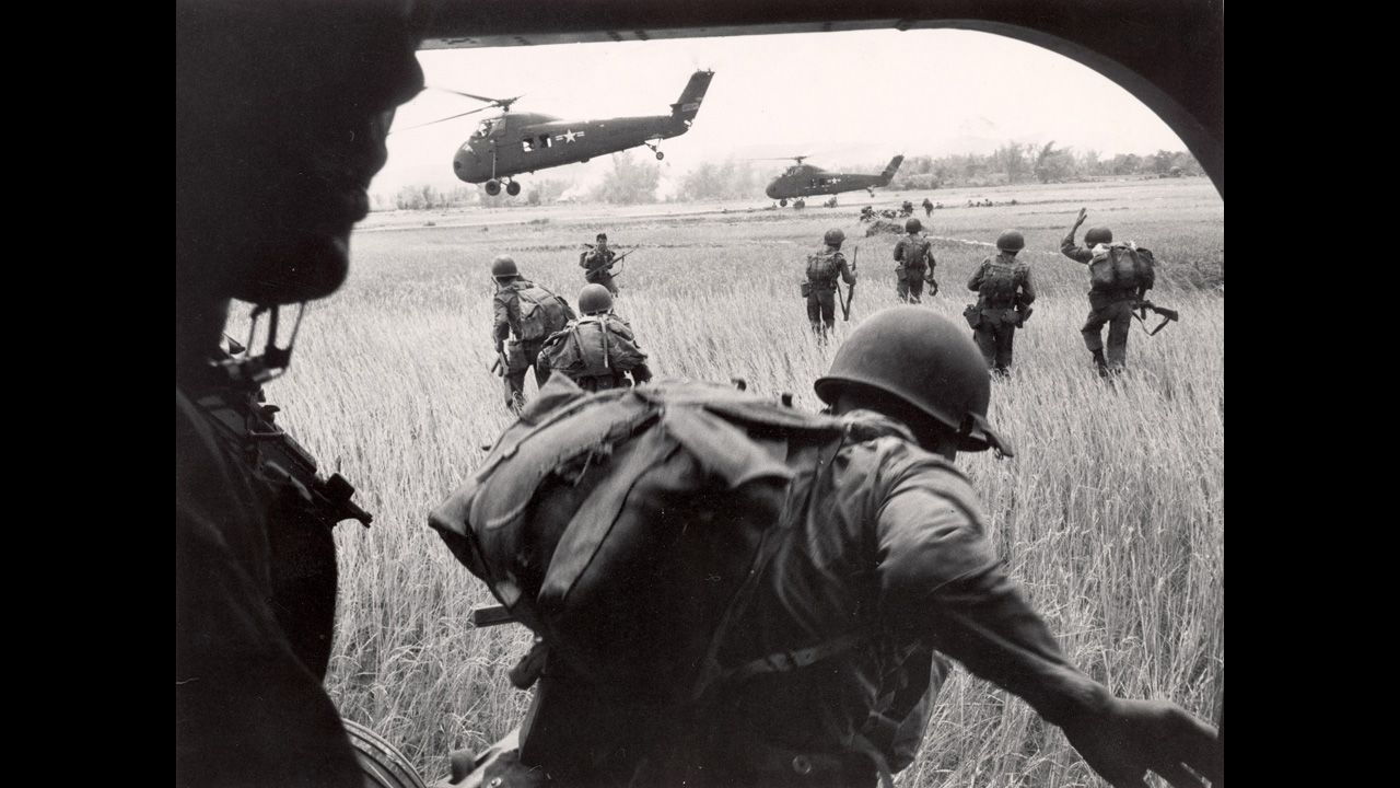 On February 9, 1965, the United States deployed its first combat troops to South Vietnam, significantly escalating its role in the war. Here, the U.S. Marines' 163rd Helicopter Squadron discharges South Vietnamese troops for an assault against the Viet Cong hidden along the tree line in the background.
