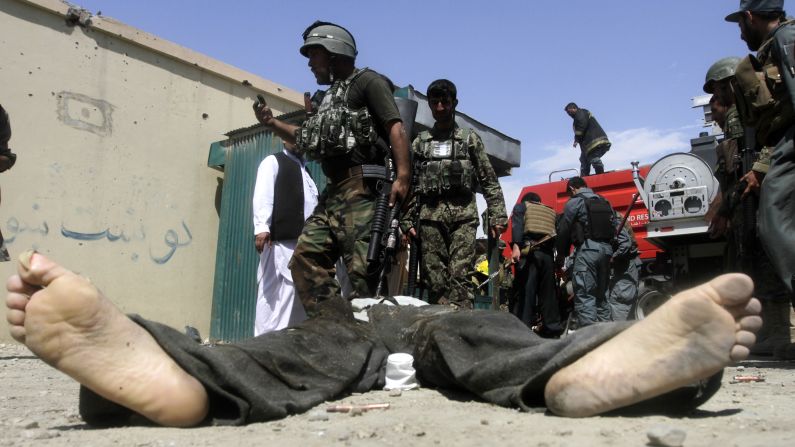 Afghan security forces gather around the body of a Taliban insurgent after Taliban fighters stormed a government building Monday, May 12, in Afghanistan's Jalalabad province. Taliban militants <a href="http://www.cnn.com/2014/05/12/world/asia/afghanistan-violence/index.html">launched a wave of attacks</a> across the country, the first day of their annual spring offensive.