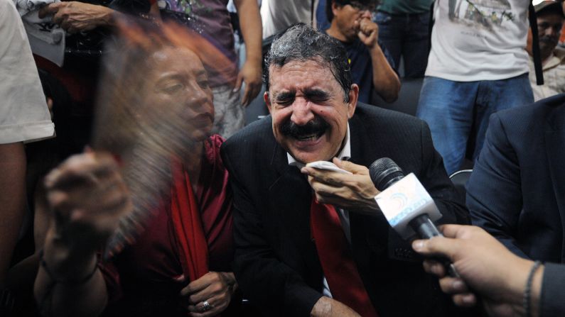 Manuel Zelaya, the former Honduran President who is now a congressman, reacts outside the Congress building after he and other members of his party were tear gassed Tuesday, May 13, in Tegucigalpa, Honduras. Zelaya, his wife and hundreds of supporters clashed with riot police and soldiers after they burst into the Congress building demanding their right to speak.