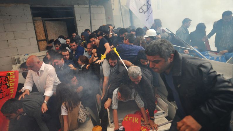 People protesting <a href="http://www.cnn.com/2014/05/13/europe/gallery/turkey-mine-accident/index.html">the Turkish mine disaster</a> run away from tear gas during a demonstration in Istanbul on Wednesday, May 14.