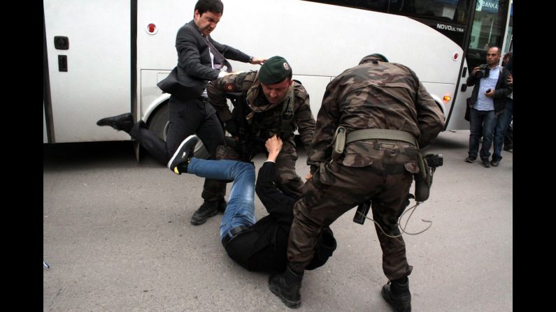 Yusuf Yerkel, an aide to Turkish Prime Minister Recep Tayyip Erdogan, kicks a person who is being wrestled to the ground by two police officers during protests in Soma, Turkey, on Wednesday, May 14. Hundreds of protesters have taken <a href="http://www.cnn.com/2014/05/15/middleeast/gallery/turkey-mine-protests/index.html">to the streets</a> across Turkey following a <a href="http://www.cnn.com/2014/05/13/europe/gallery/turkey-mine-accident/index.html">deadly mine fire</a> that occurred near Soma on May 13. 