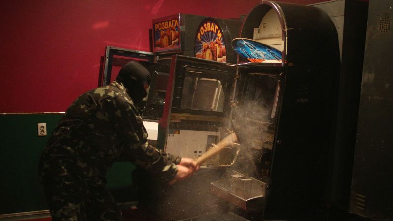 A member of a "self-defense" squad smashes a slot machine with a sledgehammer Monday, May 12, at an illegal club in Slovyansk, Ukraine. Pro-Russian militants are <a href="http://www.cnn.com/2014/03/26/world/gallery/ukraine-crisis/index.html">tightening their grip</a> on Ukraine's east and south in the worst East-West crisis since the end of the Cold War.