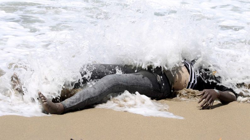 The body of an illegal migrant lies on the shore of al-Qarboli, Libya, on Wednesday, May 14. Libyan officials said at least 40 people died and around 50 were rescued when a boat carrying mostly sub-Saharan migrants <a href="http://www.cnn.com/2014/05/11/world/meast/libya-boat-migrants/index.html">sank off the coast of Tripoli</a> on May 11.
