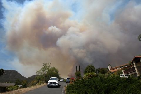 Smoke rises as a wildfire closes in on houses near San Marcos on May 15.
