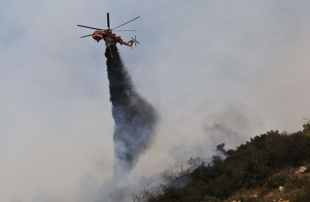 A helicopter drops retardants onto a wildfire May 15 in San Marcos. 