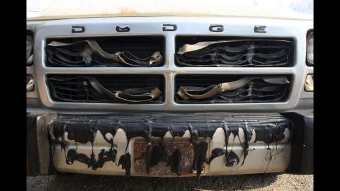 The grille of a pickup truck is left melted by a wildfire in San Marcos.