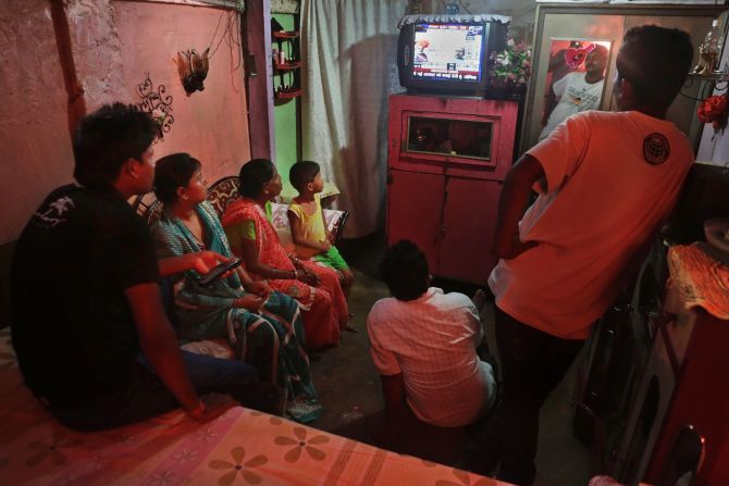 A family follows election results on TV in Guwahati on May 16.
