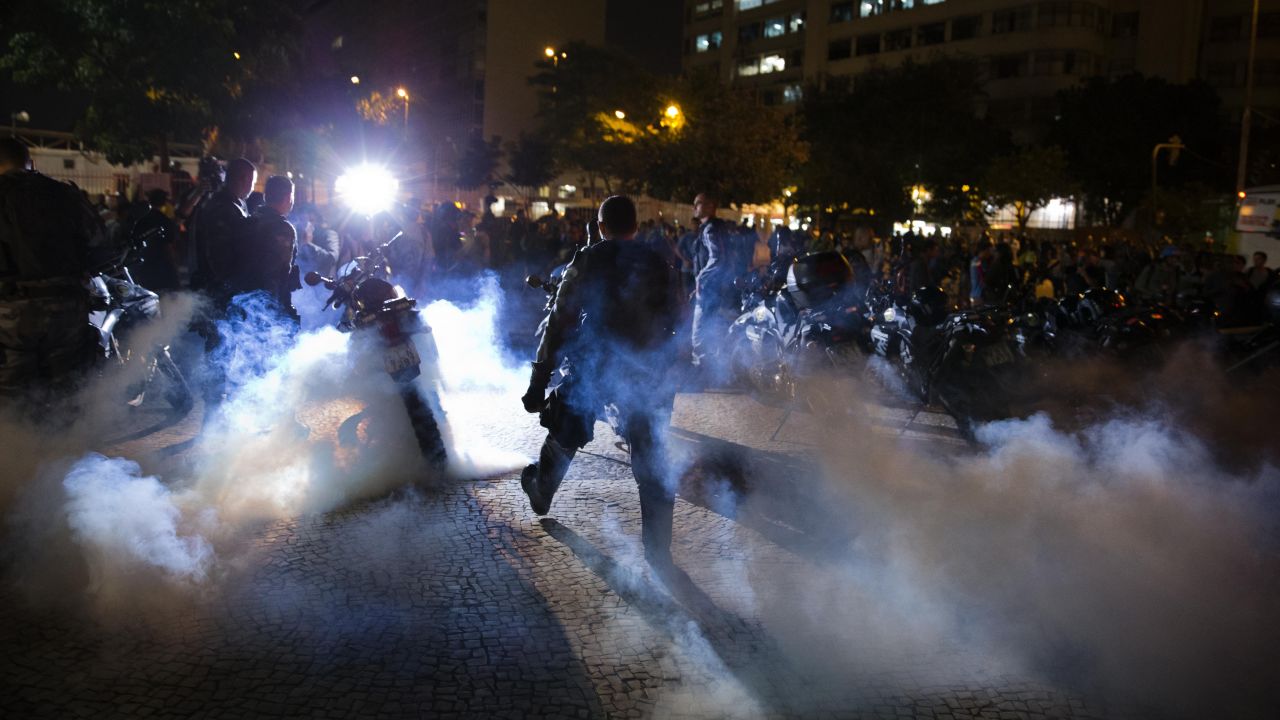 Police officers walk through a cloud of tear gas during a protest in Rio de Janeiro on May 15.