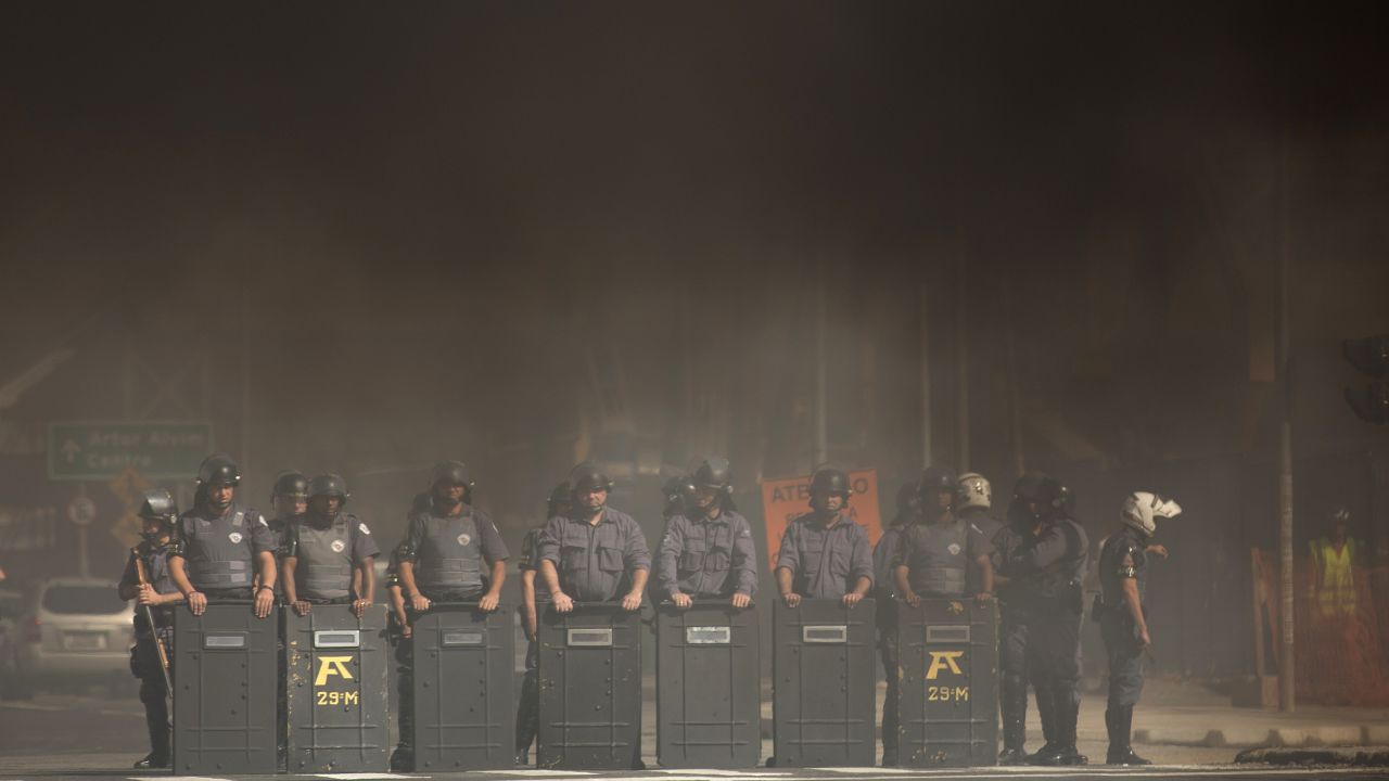 Riot police stand amid smoke coming from burning tires in Sao Paulo on May 15.