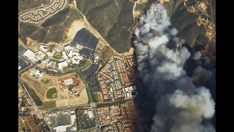 A wildfire burns near homes and California State University in San Marcos on Wednesday, May 14.