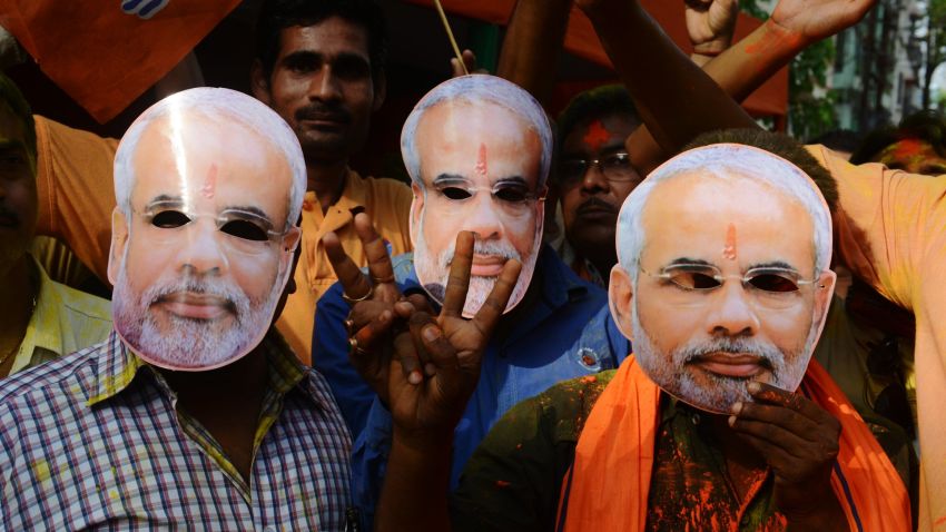 Indian supporters of the Bharatiya Janata Party (BJP) pose for a photograph wearing masks of party leader Narendra Modi outside a counting centre in Siliguri on May 16.