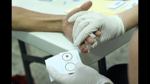 With a finger prick, the Argentine Forensic Anthropology Team takes a blood sample from family members in Honduras to extract DNA that will be matched against a database of forensic samples collected in Arizona.
